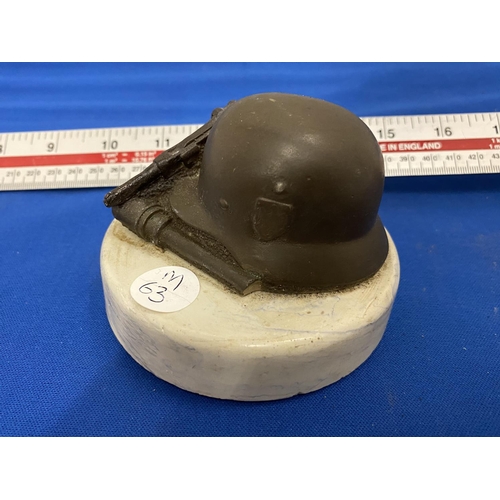 375 - A VINTAGE PAPERWEIGHT WITH  GERMAN HELMET, LUGER AND GRENADE