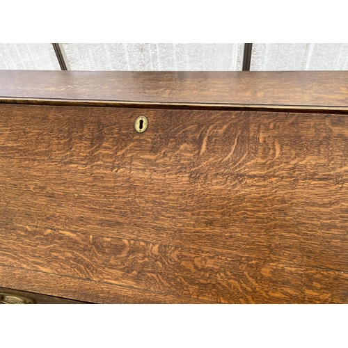 1510 - A GEORGIAN OAK BUREAU ON BRACKET FEET WITH FALL FRONT WITH FOUR DRAWERS HAVING BRASS HANDLES AND ESC... 