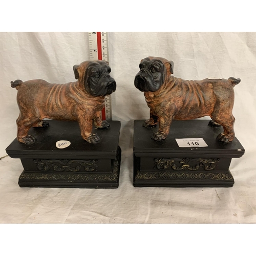 110 - A PAIR OF BULLDOGS ON ORNATE PLINTHS