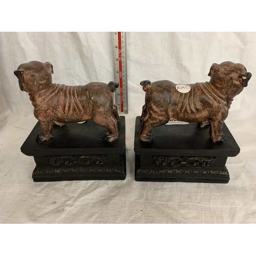 110 - A PAIR OF BULLDOGS ON ORNATE PLINTHS