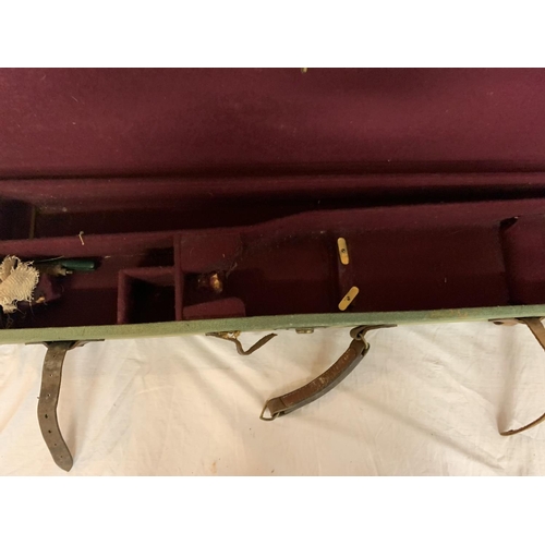 191 - A GREEN CANVAS GUN CASE WITH LEATHER STRAPS (HANDLE A/F)