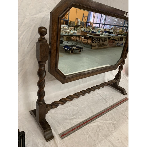 31 - AN OAK FRAMED MIRROR ON A BARLEY TWIST FRAME