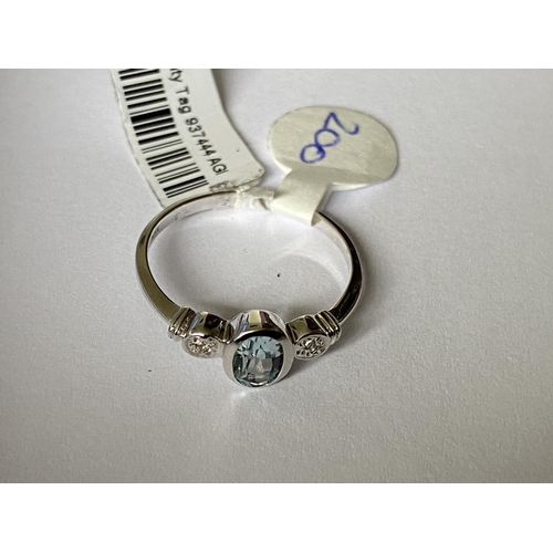 625 - A 9 CARAT WHITE GOLD RING WITH CENTRE AQUAMARINE AND TWO DIAMOND CHIPS (0.01 CARAT) - RING SIZE M+