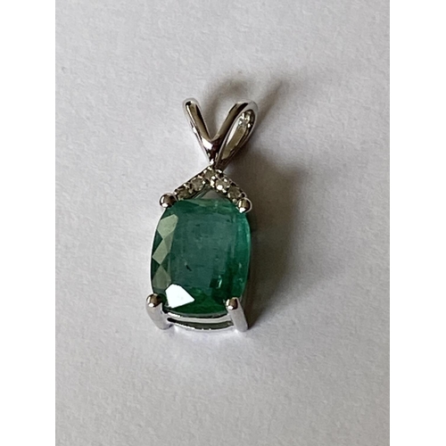 632 - A 9 CARAT WHITE GOLD EMERALD AND DIAMOND PENDANT (0.03 CARAT)