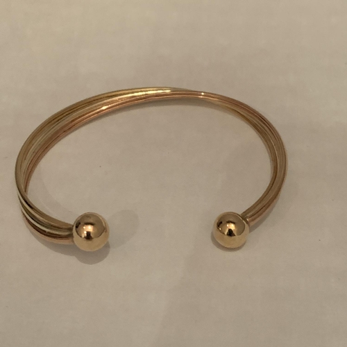 615 - 9CT HALLMARKED THREE COLOUR TWIST TORQUE BANGLE. TOTAL GROSS WEIGHT 5.2 GRAMS