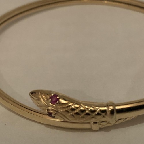 616 - A 9 CARAT GOLD SNAKE BANGLE WITH RED STONE SET EYES. TOTAL GROSS WEIGHT 8.7 GRAMS