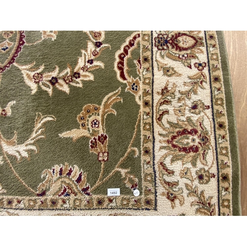 1492 - A LARGE GREEN PATTERNED RUG 160 CM X 230 CM