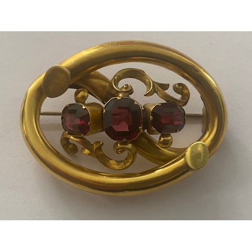 601 - A YELLOW METAL PINCHBECK BROOCH SET WITH THREE GARNETS