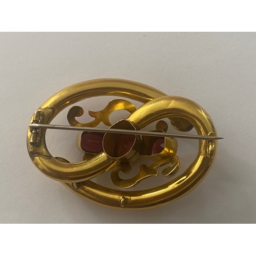 601 - A YELLOW METAL PINCHBECK BROOCH SET WITH THREE GARNETS