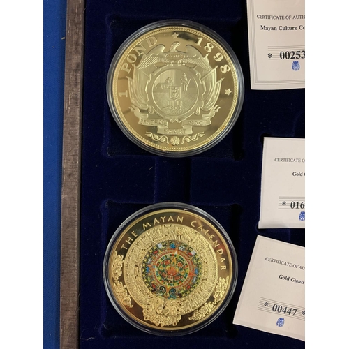 833 - A BOXED SET OF FOUR LARGE LIBERTY COINS DEPICTING THE MAYAN CALENDAR AND GOLD GIANTS