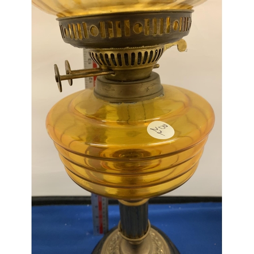 128 - AN AMBER GLASS OIL LAMP