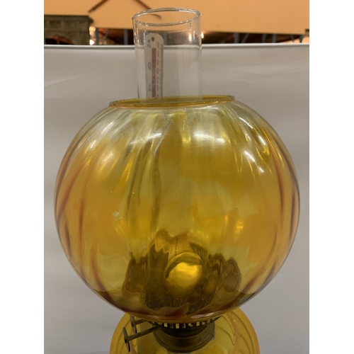 128 - AN AMBER GLASS OIL LAMP