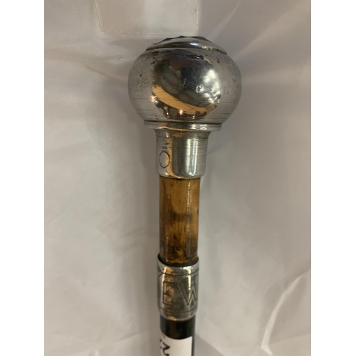 223 - A WOOD AND WHITE METAL WALKING CANE WITH ORNATE TOP AND ENGRAVED FINALE