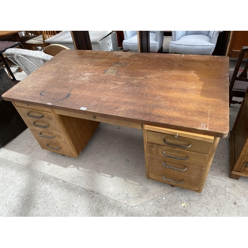 2154 - AN ABBESS OAK DESK WITH NINE DRAWERS