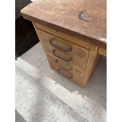 2154 - AN ABBESS OAK DESK WITH NINE DRAWERS