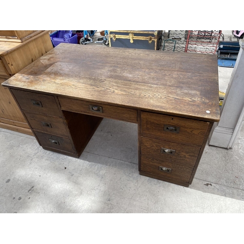 2159 - AN OAK DESK WITH SEVEN DRAWERS