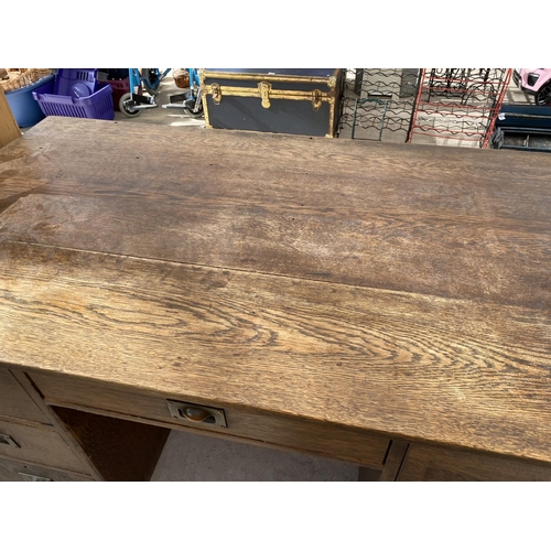 2159 - AN OAK DESK WITH SEVEN DRAWERS