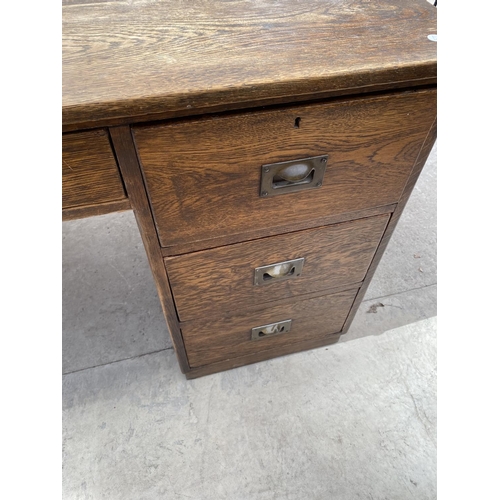 2159 - AN OAK DESK WITH SEVEN DRAWERS