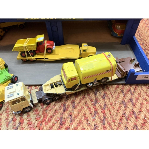 394 - A WOODEN 'TRANSPORT' GARAGE WITH TEN MATCHBOX AND CORGI MODELS OF LOW LOADERS AND PLANT