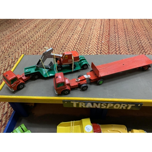 394 - A WOODEN 'TRANSPORT' GARAGE WITH TEN MATCHBOX AND CORGI MODELS OF LOW LOADERS AND PLANT