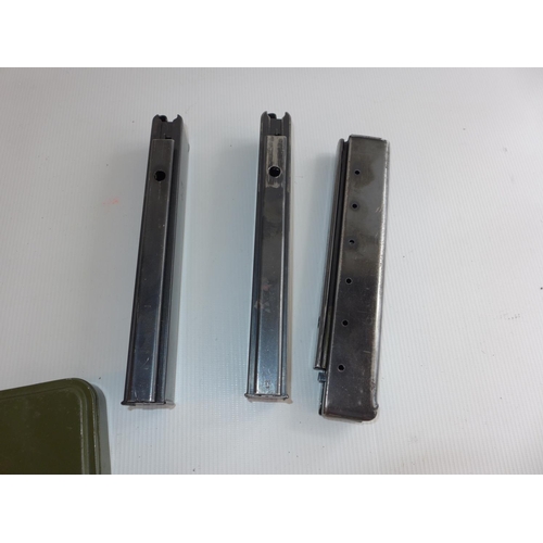 323 - THREE MACHINE GUN MAGAZINES AND A CASED GUN CLEANING KIT