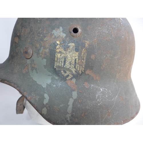 375 - A GERMAN WORLD WAR II HELMET, COMPLETE WIH INNER LINER AND CHIN STRAP. ACCORDING TO THE VENDOR THIS ... 