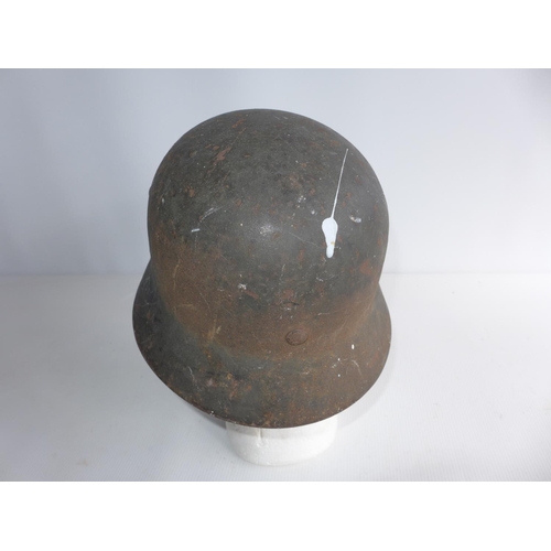 375 - A GERMAN WORLD WAR II HELMET, COMPLETE WIH INNER LINER AND CHIN STRAP. ACCORDING TO THE VENDOR THIS ... 