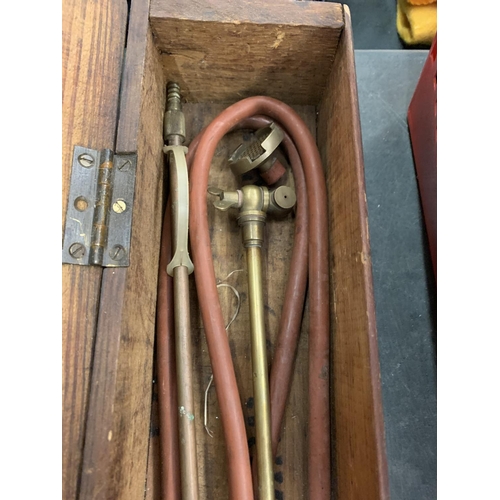 78 - AN OLD WOODEN BOX CONTAINING BRASS AND COPPER TORCH