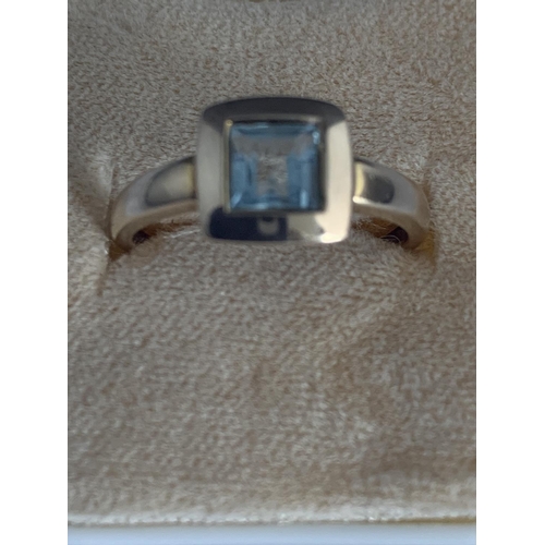 541 - A 9 CARAT GOLD RING WITH LIGHT BLUE STONE