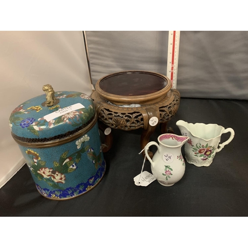 773 - A LARGE ORIENTAL CLOISONNE LIDDED JAR ON AN ORNATE CARVED WOODEN STAND AND TWO SMALL JUGS