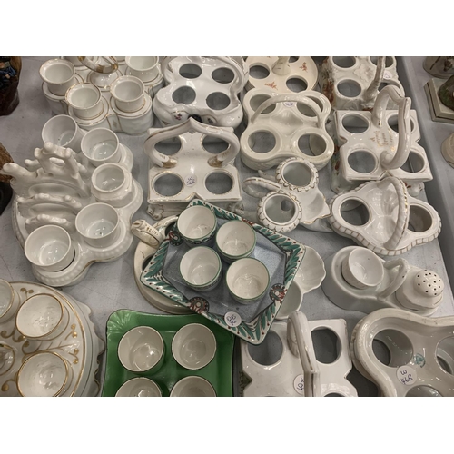 146 - A LARGE COLLECTION OF CERAMIC EGG CUPS AND HOLDERS