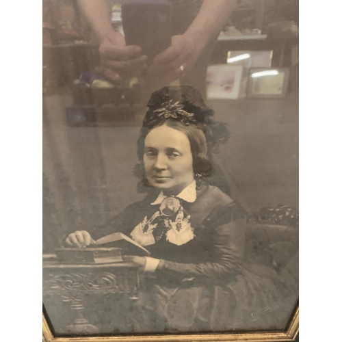 165 - A LARGE ORNATE GILT AND BLACK FRAME CONTAINING A PICTURE OF A VICTORIAN WOMAN