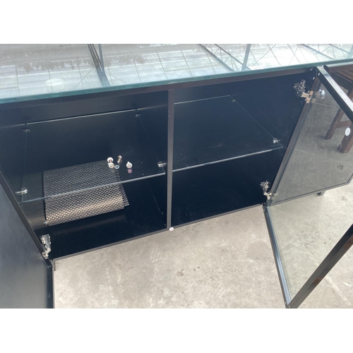 1932 - A MODERN BLACK SIDEBOARD WITH THREE DOORS AND GLASS TOP