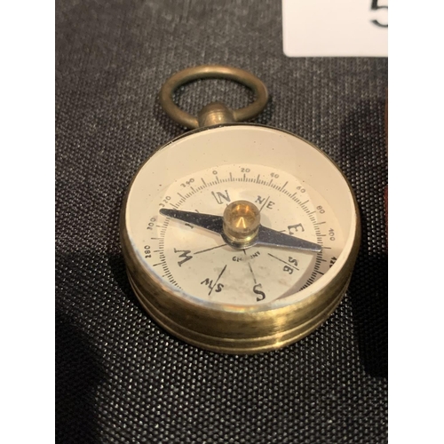 574 - A BRASS COMPASS IN A LEATHER CASE