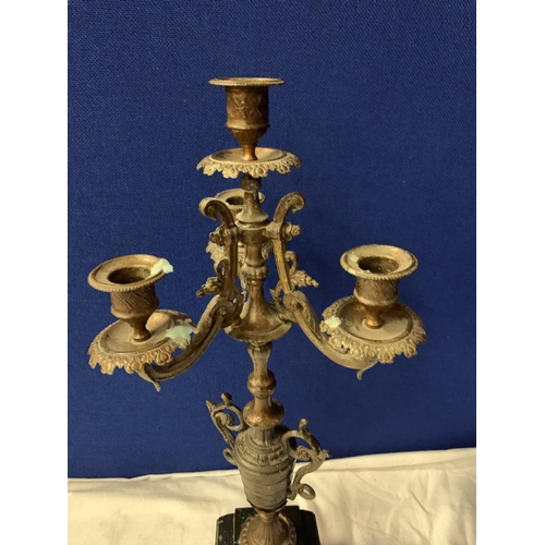 14 - AN ORNATE SPELTER FOUR CANDLESTICK MOUNTED ON A POLISHED SLATE BASE