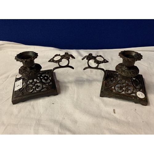 5 - A PAIR OF ARTS AND CRAFTS CAST IRON CANDLE STICKS