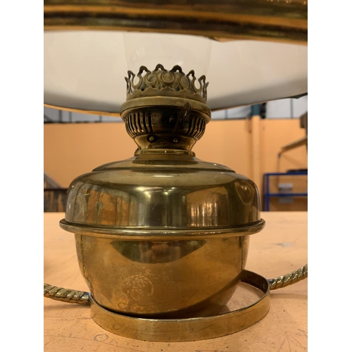 52 - A DECORATIVE BRASS OIL LAMP WITH AN OPAQUE GLASS SHADE AND HANGING HANDLE.  TO INCLUDE A SPARE SHADE