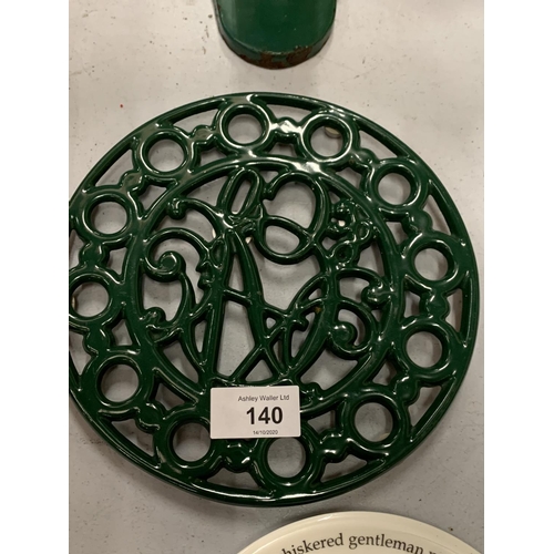 140 - A GREEN CAST METAL TRIVET AND A GREEN METAL RECIPE BOOK HOLDER