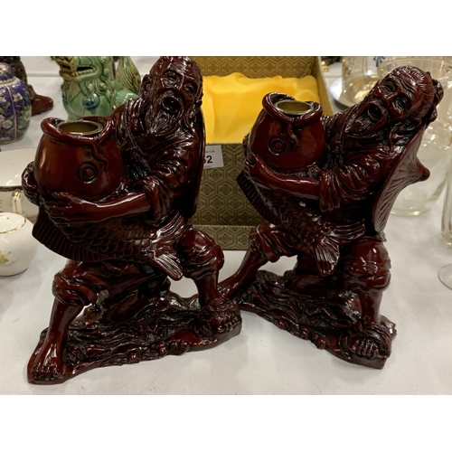 152 - TWO ORIENTAL RESIN CANDLE HOLDERS FEATURING AN ORIENTAL FISHERMAN AND CARP