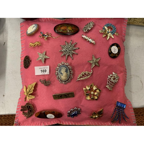 169 - A QUANTITY OF BROOCHES TO INCLUDE CAMEOS ON A PINK FELT CUSHION