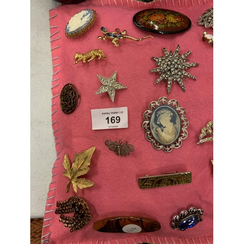 169 - A QUANTITY OF BROOCHES TO INCLUDE CAMEOS ON A PINK FELT CUSHION