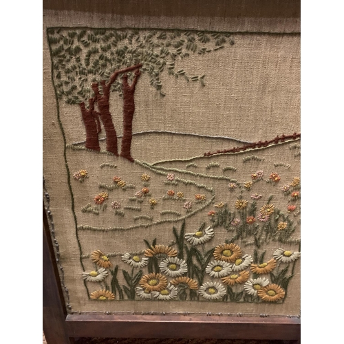 235 - A HAND EMBROIDERED FIRESCREEN ON A WOODEN STAND