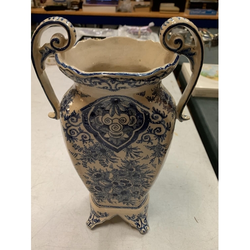 419 - A TWO HANDLED BLUE AND WHITE DECORATIVE VASE IN AN ORIENTAL STYLE