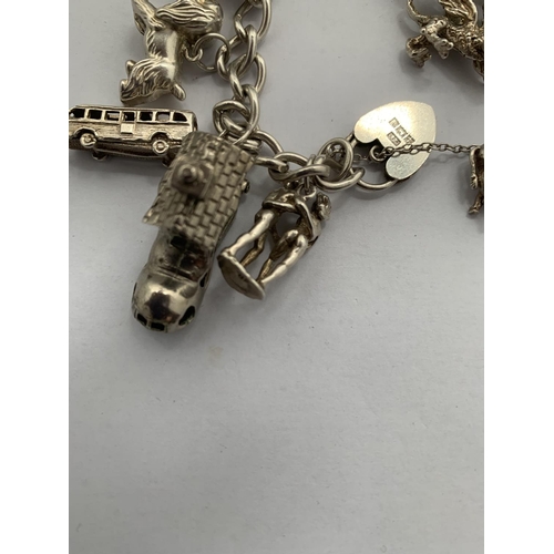 606 - A HALLMARKED SILVER CHARM BRACELET WITH TWELVE CHARMS