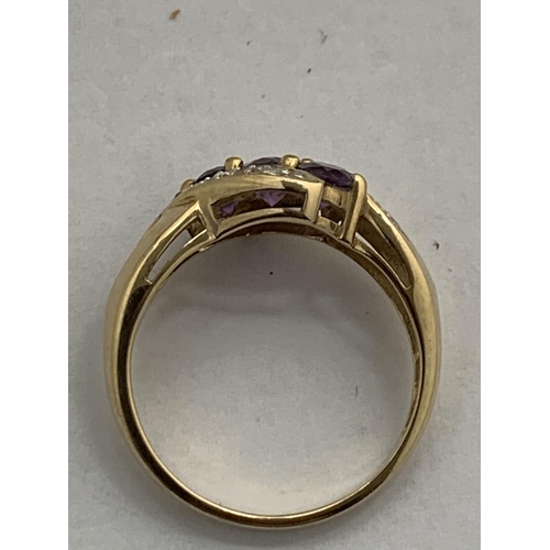 609 - A 9 CARAT GOLD RING WITH DIAMONDS AND PURPLE STONES