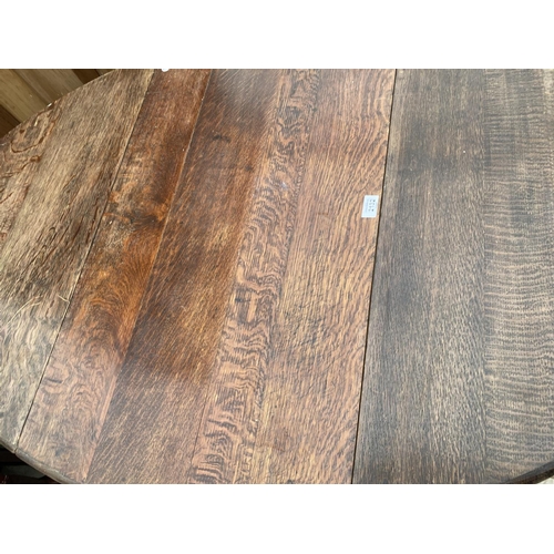 2132 - AN OVAL OAK DROP LEAF DINING TABLE ON BARLEY TWIST SUPPORTS - 53