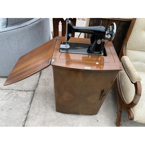 2141 - A VINTAGE SINGER SEWING MACHINE IN A WALNUT CABINET