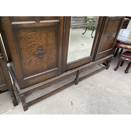 2148 - AN EARLY 20TH CENTURY JACOBEAN STYLE CARVED AND PANELED OAK THREE PIECE BEDROOM SUITE ON TURNED SUPP... 