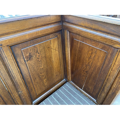 1804 - A GEORGE III STYLE OAK ENCLOSED SETTLE WITH PANELLED BACK AND SIDES ON OPEN TURNED BASE, 50