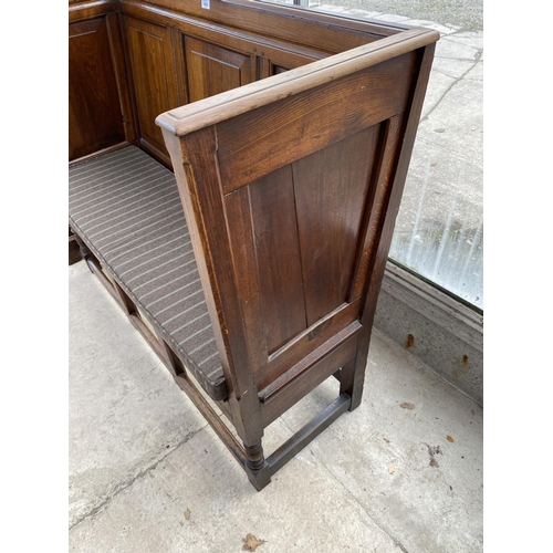 1804 - A GEORGE III STYLE OAK ENCLOSED SETTLE WITH PANELLED BACK AND SIDES ON OPEN TURNED BASE, 50